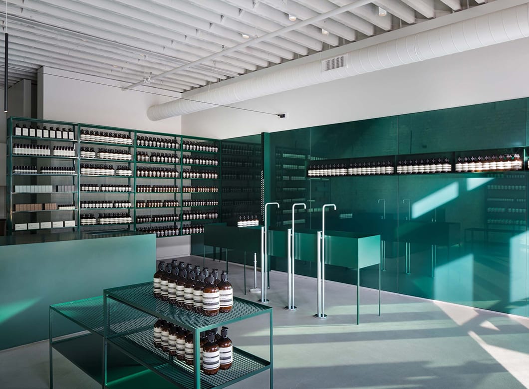 A view of the interior of Aesop West Loop, with Archetype Glass' custom glass wall cladding and shelves