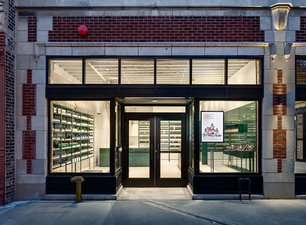 An exterior view of the Aesop West Loop, featuring custom glass wall cladding by Archetype Glass