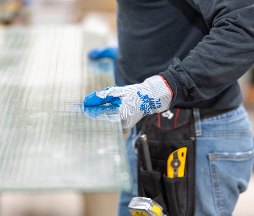 An Archetype Glass team member handling custom laminated art glass