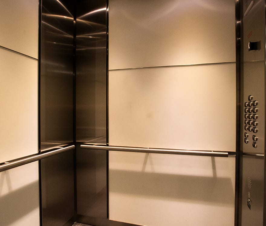 The custom laminated glass elevator cabs in the 6402 Arlington Boulevard elevator