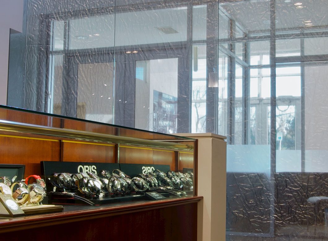 An view of the trans-viewability of the custom glass partition wall at Radcliffe Jewelers, created by Archetype Glass