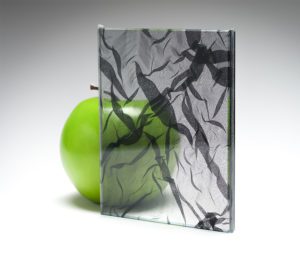 A sample of highly transparent custom fabric glass featuring custom fabric from Spatial Element