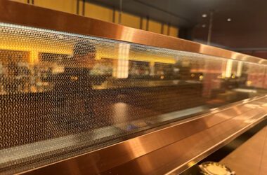 A close view of the custom laminated wire mesh glass used in the Coqodaq restaurant, recently featured in Hospitality Design Magazine